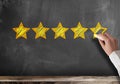 Five star customer feedback or client service rating on blackboard Royalty Free Stock Photo