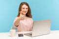 Excellent job! Positive satisfied woman with charming toothy smile showing thumbs up gesture, like, approval sign Royalty Free Stock Photo