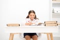 Excellent pupil. Girl child writes hometask while sit table white background. Schoolgirl studying writing essay. Kid