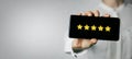 Excellent service and customer feedback. woman holding phone with 5 star rating on screen. copy space Royalty Free Stock Photo