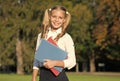 Excellent student girl study with school book outdoors, free courses concept