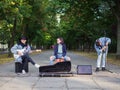 Young guy sings songs and plays guitar on a jeans jacket in a park on a natural background. Royalty Free Stock Photo