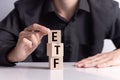 Exchance Traded Fund investing concept , a man`s hand builds a tower of cubes with letters ETF Royalty Free Stock Photo