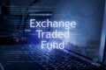 Exchange traded fund inscription against laptop and code background. Financial concept