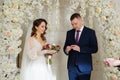 exchange wedding rings.bride and groom in an arch of flowers at wedding ceremony Royalty Free Stock Photo