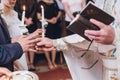 Exchanging wedding rings. priest putting on golden wedding rings on fingers bride and groom in church at wedding matrimony. Royalty Free Stock Photo