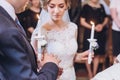 Exchanging wedding rings. priest putting on golden wedding rings on fingers bride and groom in church at wedding matrimony.