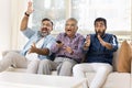 Excited adult Indian men of three generations watching sport match Royalty Free Stock Photo