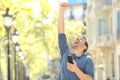 Excited adult man holding phone celebrating success