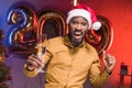 excited african american businessman in santa hat holding glass of champagne at new year Royalty Free Stock Photo