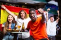 Excited African American cheering for favorite Spanish team in sports bar Royalty Free Stock Photo
