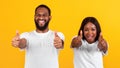 Excited African American couple gesturing thumbs up and smiling Royalty Free Stock Photo