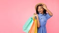 Excited African Girl Carrying Shopper Bags Looking Aside, Pink Background