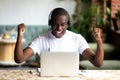 Excited African American man in headphones celebrating success Royalty Free Stock Photo