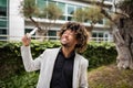 Excited african american middle aged businessman holding money cash, recommending investment, trading, standing outdoors