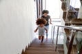 Excited African American mom and daughter run upstairs new home Royalty Free Stock Photo