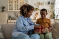 Excited African American mother opening gift while celebrating Mothers Day with son at home Royalty Free Stock Photo