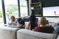 Excited african american parents, son, daughter and grandparents watching rugby on tv, slow motion