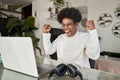 Excited African American student celebrating online win looking at laptop. Royalty Free Stock Photo