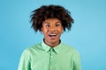 Excited african american teen guy with braces looking and smiling at camera, posing over blue studio background Royalty Free Stock Photo