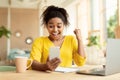 Excited african american woman looking at smartphone screen and gesturing YES, feeling happy at home Royalty Free Stock Photo