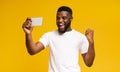 Excited African Guy Celebrating Success, Using Smartphone over Yellow Background Royalty Free Stock Photo