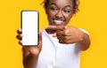 Excited african lady showing smartphone with white screen