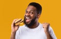 Excited African Man Eating Burger Gesturing Yes Over Yellow Background Royalty Free Stock Photo