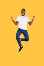 Excited African Man Jumping Shaking Fists Celebrating Success, Yellow Background Royalty Free Stock Photo