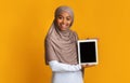 Excited Afro Islamic Girl Holding Digital Tablet With Black Screen