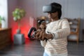 Excited afro woman wear vr glasses hold joystick experience of virtual reality headset, soft focus