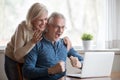 Excited aged wife and husband looking on computer screen Royalty Free Stock Photo