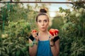 Funny Farm Girl Comparing a Big Tomato to a Small One Royalty Free Stock Photo