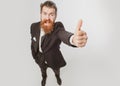 Excited amazed business man in black suit smiling and showing thumbs up. Escape from crisis. Funny face. Great Idea