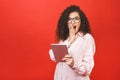 Excited amazed young beautiful woman with tablet pc. Happy girl in white shirt using tablet computer, isolated on red background Royalty Free Stock Photo