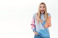 Excited, amused blonde caucasian girl in hoodie, long fair hair, smiling amazed and laughing as showing good promo