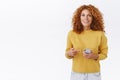 Excited, amused happy smiling redhead female with curly hair, hold smartphone, pointing mobile display and grinning as