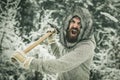 Excited angry man lumberjack with axe in snowy forest