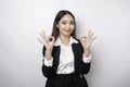 Excited Asian business woman wearing a black suit giving an OK hand gesture isolated by a white background Royalty Free Stock Photo
