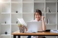 Excited Asian businesswoman sitting at the table feeling happy at winning happy asian woman receiving promoted documents Royalty Free Stock Photo