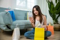 Excited Asian buying woman holding mobile phone with many shopping bags Royalty Free Stock Photo