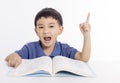 Excited asian child schoolboy studying at home