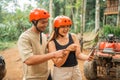 excited asian couple with savety helmet pointing on the phone screen Royalty Free Stock Photo