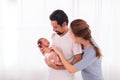 Excited Asian father with beard hold his first child newborn with strong arm, beautiful wife play with baby and try to help Royalty Free Stock Photo