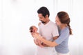 Excited Asian father with beard hold his first child newborn with strong arm, beautiful wife play with baby and try to help Royalty Free Stock Photo