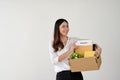 An excited Asian female employee feels happy to quit her job, holding a cardboard box with her stuff Royalty Free Stock Photo