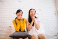 Excited Asian females sitting on sofa