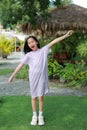 Excited Asian girl kid standing and hand up raised arms while in the garden. Full length child winner success Royalty Free Stock Photo