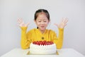 Excited asian little girl with strawberry cake. Kid with happy birthday cake on the table Royalty Free Stock Photo