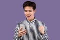 Excited asian man using mobile phone, celebrating online win Royalty Free Stock Photo